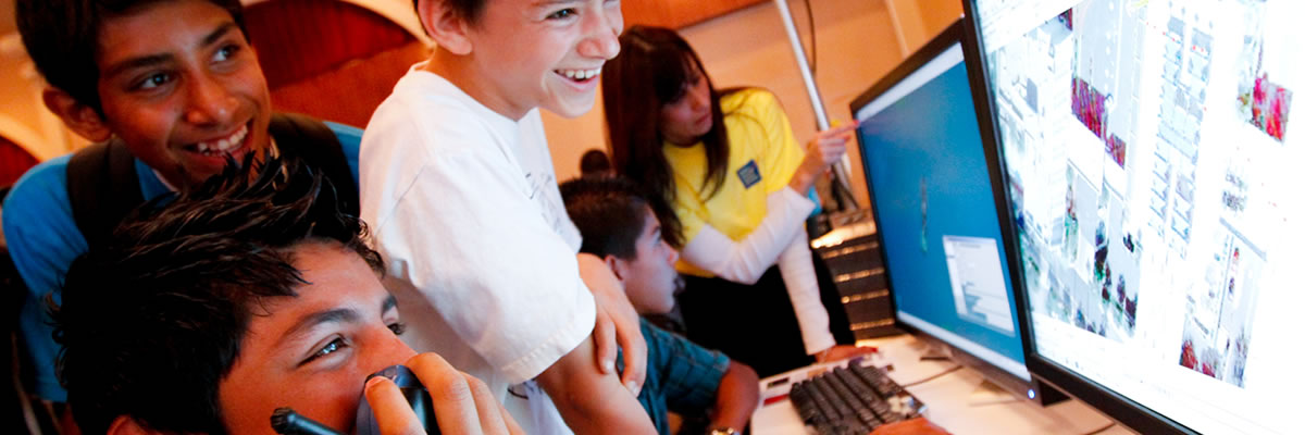 Excited students viewing work on computer screen.